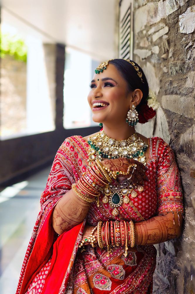 Indian Stylish bride wearing a red saree and gold bangels